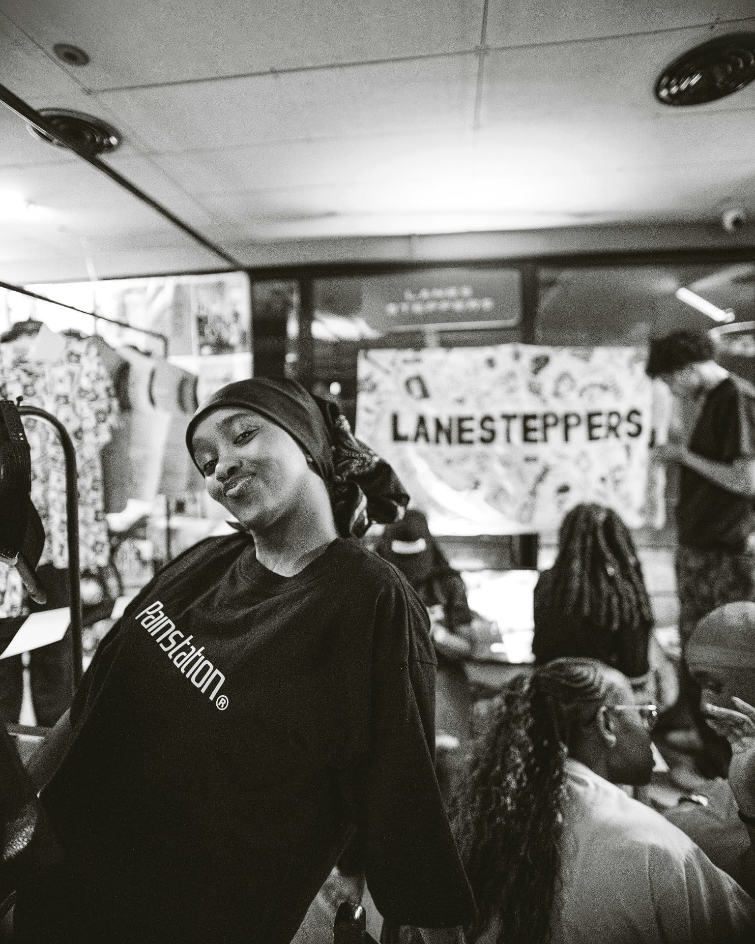 Black and white portrait of a smiling young woman at a neighborhood pop-up market