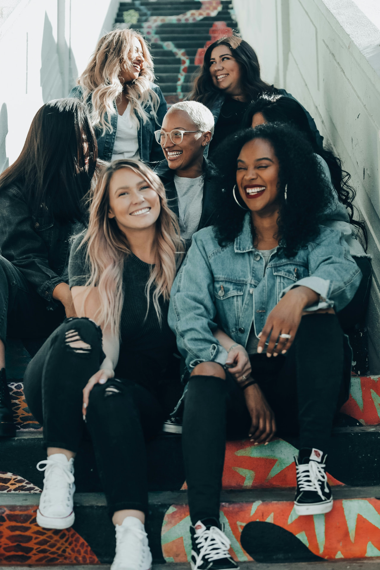 A group of friends laughing together on painted outdoor steps